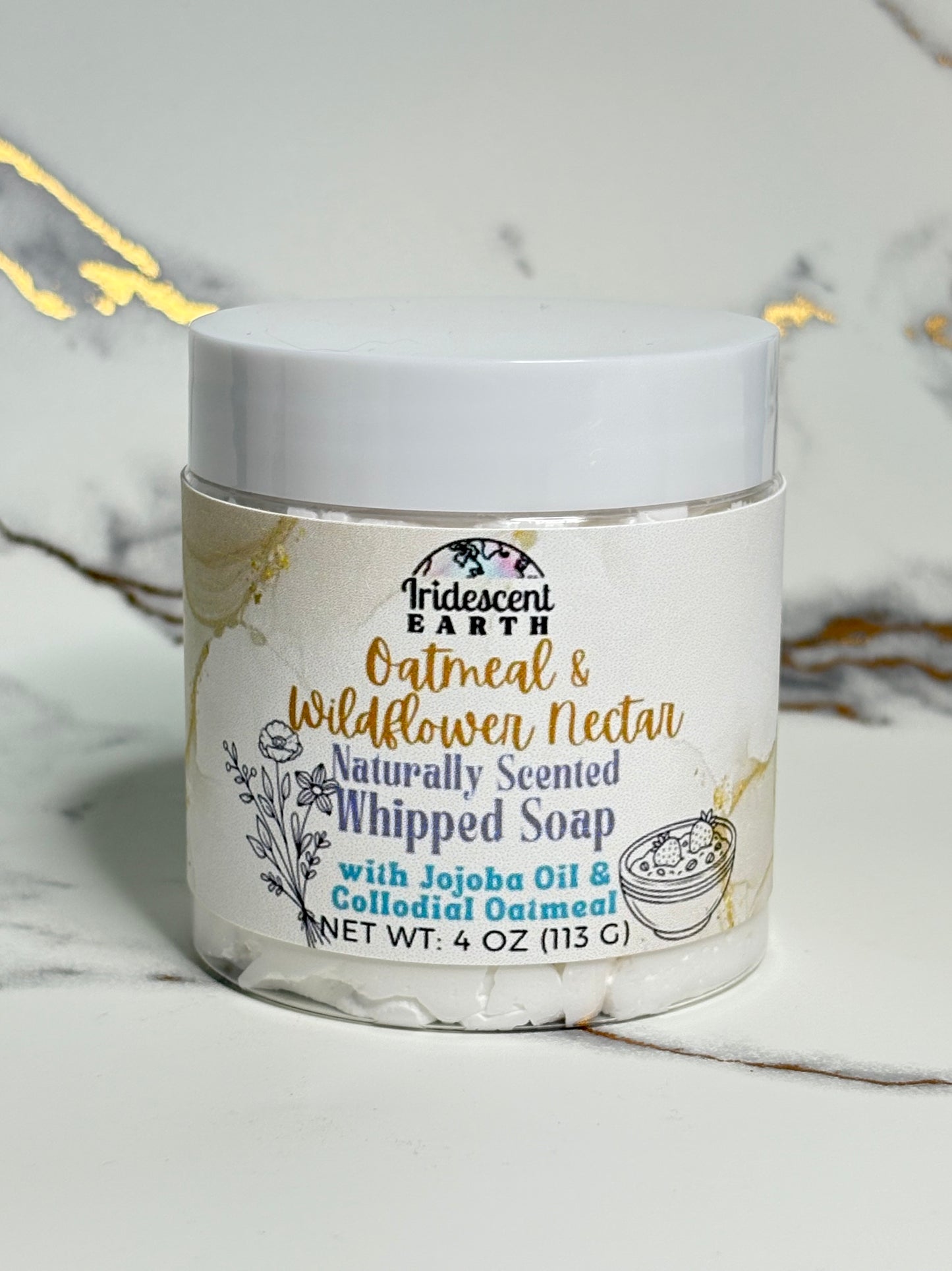 Jar of whipped soap with branding on a marble surface