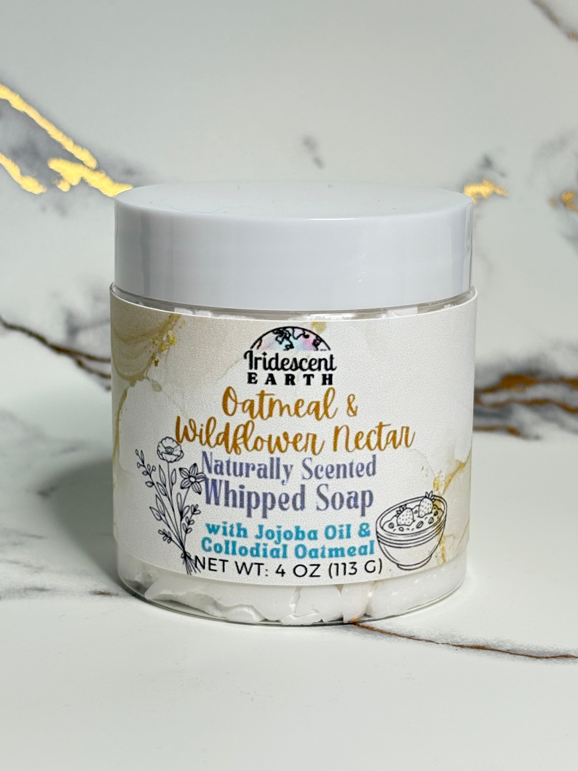 Jar of whipped soap with branding on a marble surface