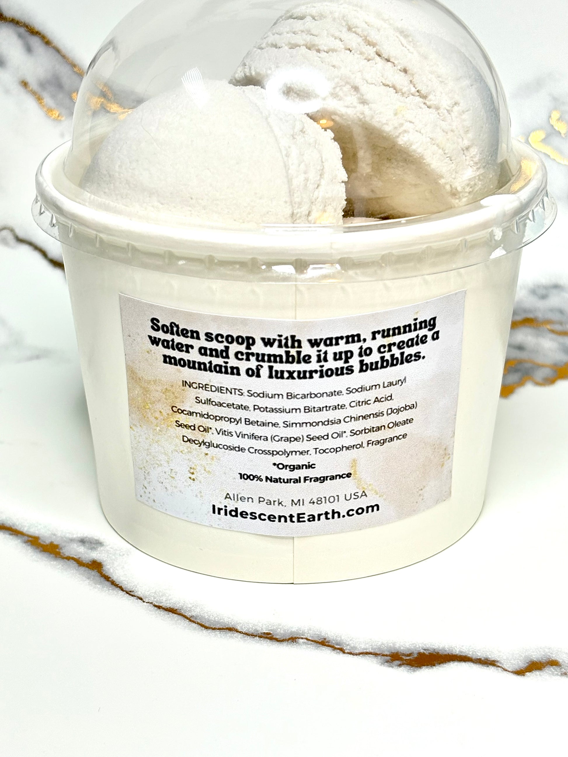 Container of bubble bath scoops with a label on a marble surface