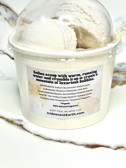 Container of bubble bath scoops with a label on a marble surface